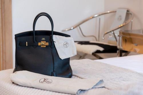 a black bag sitting on top of a bed at Luxury Seafront Villa Prestige Brac with private pool, sauna and gym and private sea deck at the beach on Brac island in Selca
