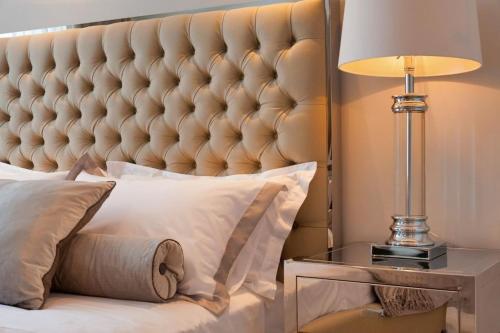 a bedroom with a large bed with a lamp on a side table at Luxury Seafront Villa Prestige Brac with private pool, sauna and gym and private sea deck at the beach on Brac island in Selca