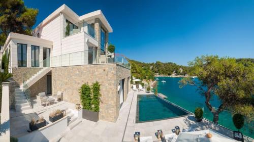 an aerial view of a house with a swimming pool at Luxury Seafront Villa Prestige Brac with private pool, sauna and gym and private sea deck at the beach on Brac island in Selca