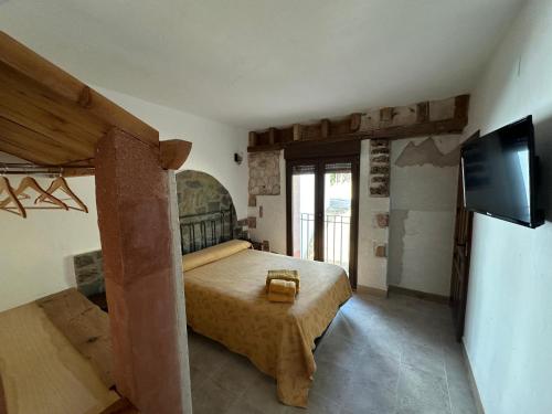 a bedroom with a bed and a flat screen tv at Casa Rural TorreMontero Apartamentos in Hornos el Viejo