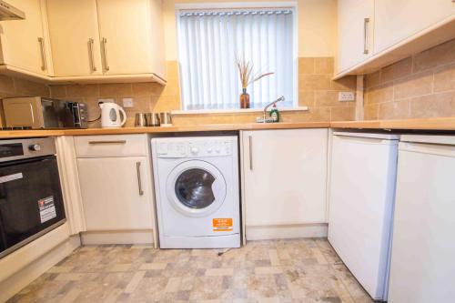 a kitchen with a washer and dryer in it at Beautiful, Peaceful, 5 Bedroom home with Hot Tub! in Manchester