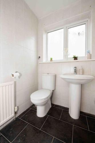 a bathroom with a white toilet and a sink at Beautiful, Peaceful, 5 Bedroom home with Hot Tub! in Manchester