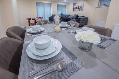 a dining room table with plates and silverware on it at Beautiful, Peaceful, 5 Bedroom home with Hot Tub! in Manchester
