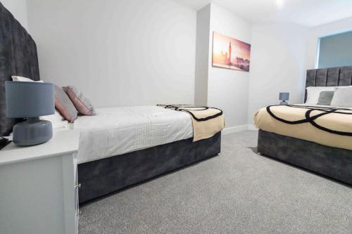 a bedroom with two beds and a table with a lamp at Beautiful, Peaceful, 5 Bedroom home with Hot Tub! in Manchester