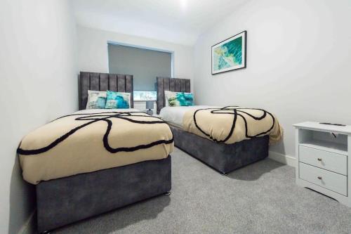 a bedroom with two beds and a desk in it at Beautiful, Peaceful, 5 Bedroom home with Hot Tub! in Manchester