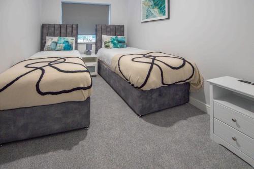 a bedroom with two beds and a dresser at Beautiful, Peaceful, 5 Bedroom home with Hot Tub! in Manchester