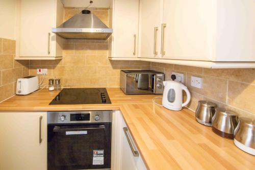 a kitchen with white cabinets and a wooden counter top at Beautiful, Peaceful, 5 Bedroom home with Hot Tub! in Manchester