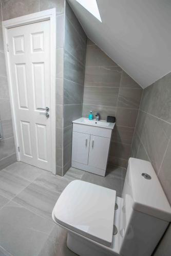 a bathroom with a white toilet and a sink at Beautiful, Peaceful, 5 Bedroom home with Hot Tub! in Manchester