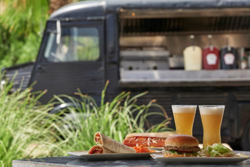 a table with two glasses of beer and a sandwich at Atlantica Marmari Palace in Mastichari