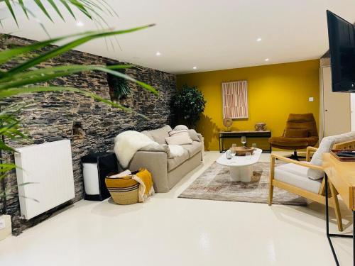 un salon avec un canapé et un mur en pierre dans l'établissement Casa Atypique, à Angers
