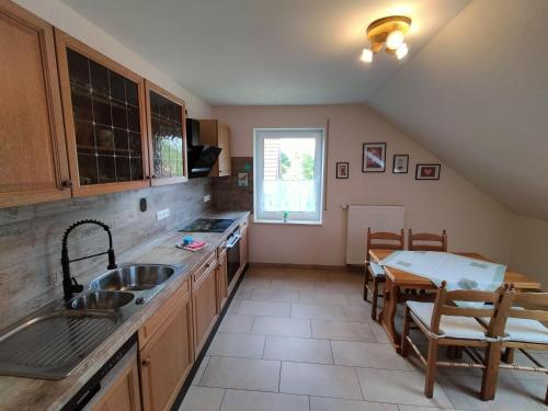 a kitchen with a sink and a table and a dining room at Ferienwohnung Karin 65355 in Moormerland