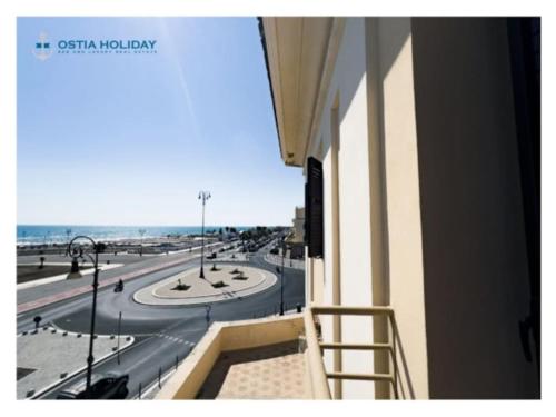 a balcony with a view of a street and the ocean at Ostia Holiday Al pontile 2 in Lido di Ostia