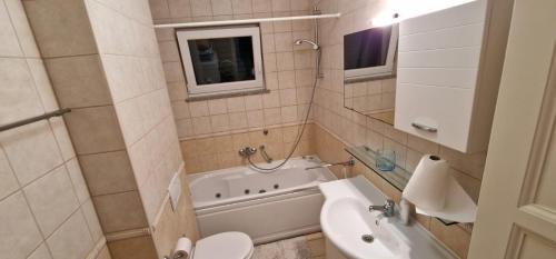 Un baño con inodoro, bañera y lavabo. en Adriapartman, en Rogoznica