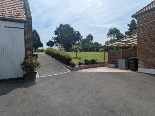 a driveway next to a building with a garage at Studio Les chambres de la source - Milouin in Sancourt