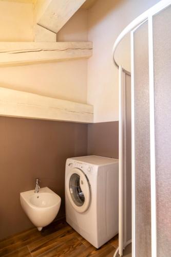 a bathroom with a washing machine and a sink at Maison Rosset agriturismo, camere, APPARTAMENTI e spa in Valle d'Aosta in Nus