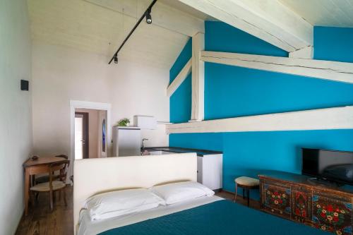 a bedroom with a bed and a blue wall at Maison Rosset agriturismo, camere, APPARTAMENTI e spa in Valle d'Aosta in Nus