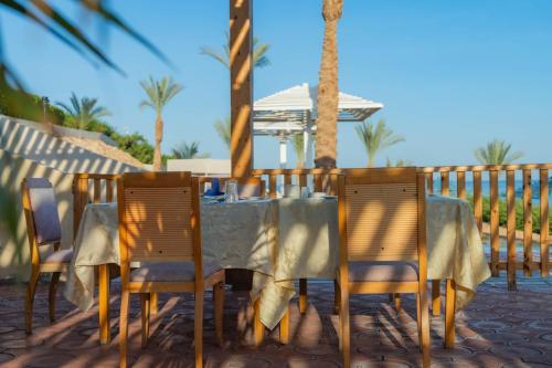 a table and chairs on a patio with palm trees at Grand Oasis Resort in Sharm El Sheikh