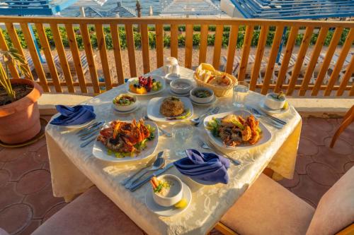 a table with plates of food on it at Grand Oasis Resort in Sharm El Sheikh