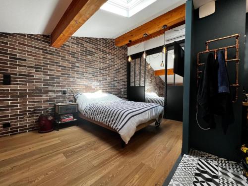 une chambre avec un lit et un mur de briques dans l'établissement Superbe Duplex à Cannes, à Cannes
