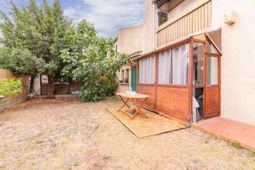 - une table de pique-nique dans une cour à côté d'un bâtiment dans l'établissement La Douce Occitane - Maison climatisée pour 6, à Carcassonne