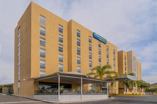 a large yellow building with a restaurant in front of it at City Express by Marriott Queretaro Jurica in Querétaro