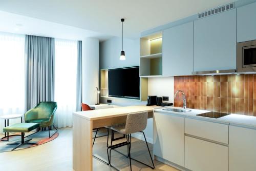 a kitchen with a counter and chairs in a room at Residence Inn by Marriott The Hague in The Hague