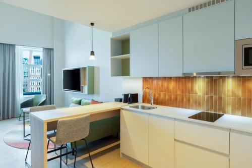 a kitchen with white cabinets and a counter top at Residence Inn by Marriott The Hague in The Hague