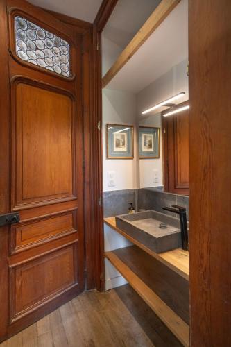 La salle de bains est pourvue d'un lavabo à côté d'une porte en bois. dans l'établissement Manoir de la Dune, à Quend