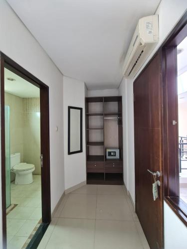 a hallway with a bathroom with a toilet and a door at Behomy Corner Eight Lippo Karawaci in Tangerang