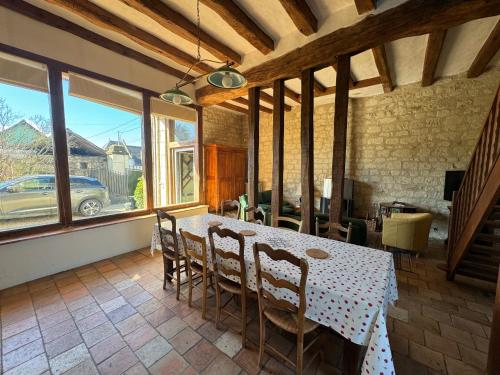 a dining room with a table and chairs and windows at GRESILLE in Beaumont-en-Véron