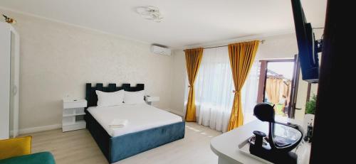 a bedroom with a bed and a television in it at Casa Sunrise Mangalia in Mangalia