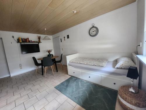 1 dormitorio con 1 cama y 1 mesa con reloj en Deluma, en Rust