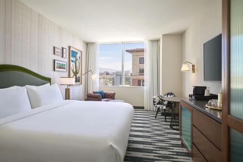 a hotel room with a large bed and a window at The Leo Kent Hotel, Tucson, a Tribute Portfolio Hotel in Tucson