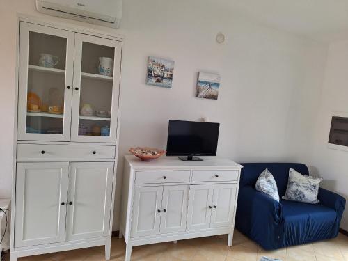 a living room with a white cabinet and a blue couch at [2 KM DAL MARE] Villetta relax con barbecue in Palmadula
