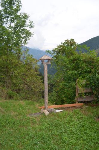 a wooden pillar in a field with a fence at Almhaus Sparwald in Teuchl