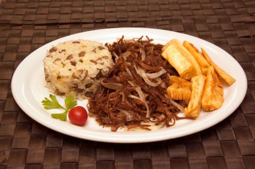 a plate of food with meat and french fries at Bristol Jangada Fortaleza Meirelles in Fortaleza