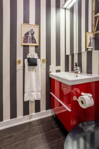 a bathroom with a red sink and striped walls at Duplex 3 Bed 2 Bat Apt Steps from Lincoln Square in Chicago