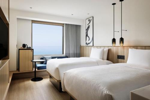 two beds in a hotel room with a window at Fairfield by Marriott Hyogo Awaji Higashiura in Awaji