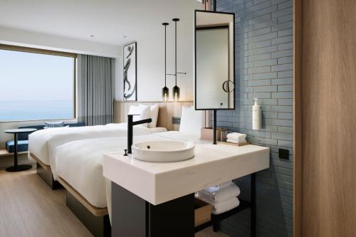 a bathroom with a sink and a bed with a mirror at Fairfield by Marriott Hyogo Awaji Higashiura in Awaji