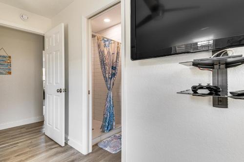 a flat screen tv on the wall of a bathroom at Cocoa Beach Home with Private Pool about half Mi to Beach in Cocoa Beach