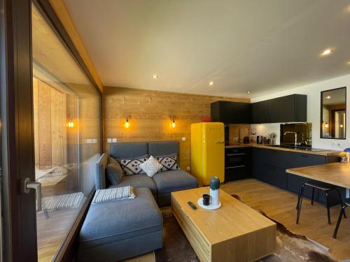 un salon avec un canapé et une cuisine dans l'établissement Homency - Résidence La Meije 5, à L'Alpe-d'Huez