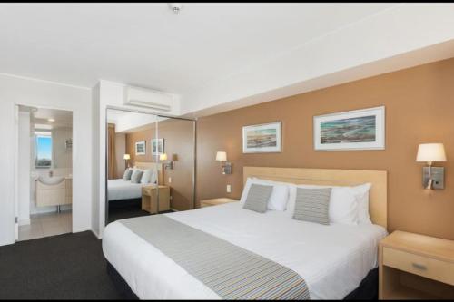 a hotel room with a large bed and a bathroom at Pool View Retreat in Ballina