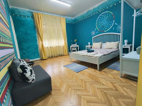 a bedroom with blue walls and a bed and a couch at Timisoara Central Vibes Belle Vue Apartments in Timişoara
