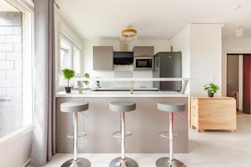 une cuisine avec un comptoir et des tabourets. dans l'établissement Appartement 1 pièce très chaleureux, à Louviers