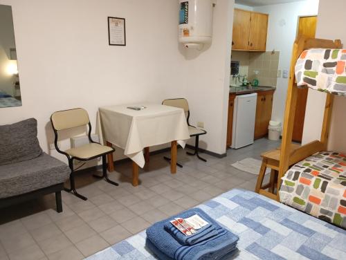 a room with a table and chairs and a kitchen at Monoambiente céntrico con balcón - Posadas, Misiones in Posadas