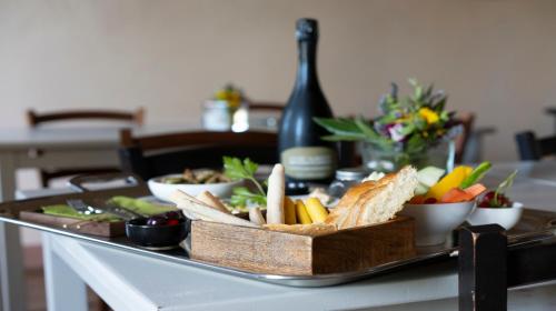 a table topped with a tray of food with bread and vegetables at Vigne di Fagnano 1709 Eco Relais in Santo Stefano Belbo