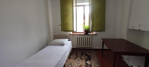 a small room with two beds and a window at Elai Guest House in Kazarman