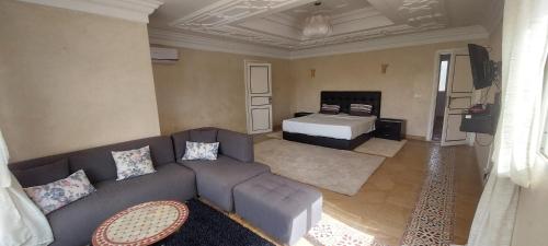 a living room with a couch and a bed at Villa Rayan Marrakech secteur Palmeraie dans Propriété de 2 hectares avec jardin arbres fruitiers in Marrakesh