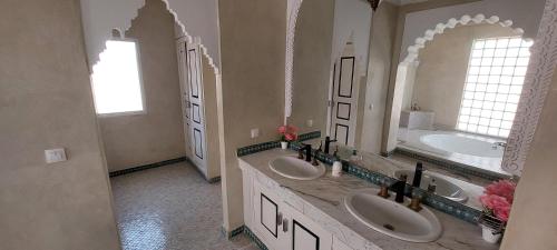 a large bathroom with two sinks and two mirrors at Villa Rayan Marrakech secteur Palmeraie dans Propriété de 2 hectares avec jardin arbres fruitiers in Marrakesh