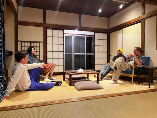 a group of people sitting in a room at Guesthouse Azumaya in Matsumoto